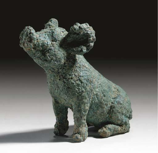 Cerdito de bronce de época romana Pequeña figura de bronce romana con forma de cerdito sentado, fotografiada sobre fondo oscuro.
