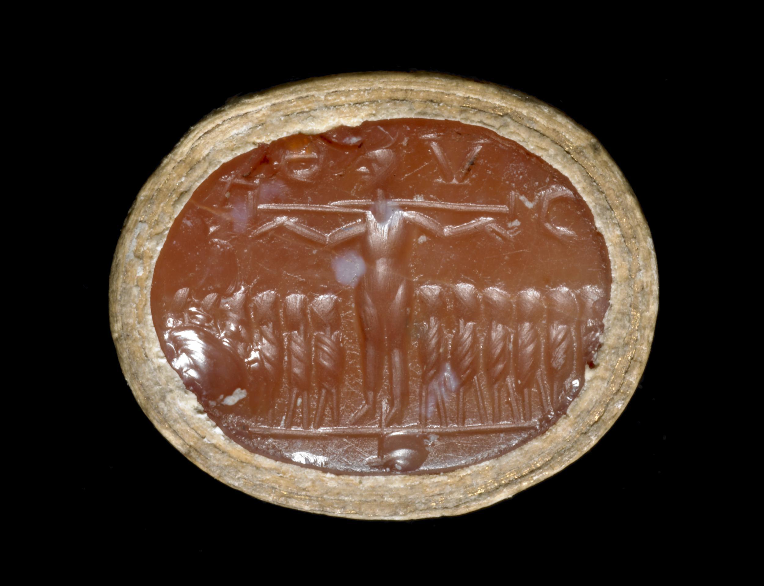 Gema de Constanza con escena de crucifixión Gema ovalada de cornalina de Constanza con una figura crucificada y doce figuras alineadas.